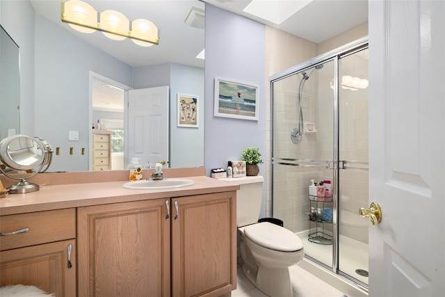 bathroom featuring vanity, a skylight, toilet, and a stall shower