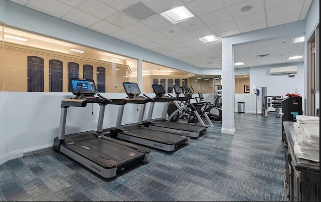 workout area with a paneled ceiling, baseboards, and a wall mounted AC