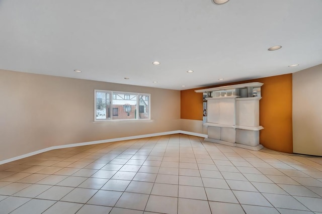 empty room featuring light tile patterned floors, baseboards, and recessed lighting