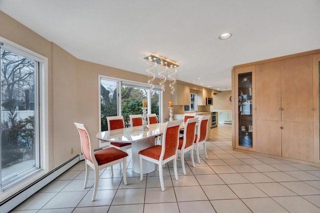 dining room featuring light tile patterned floors, baseboard heating, an inviting chandelier, and a wealth of natural light