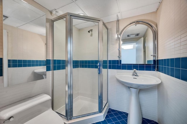full bath featuring visible vents, tile walls, and a stall shower