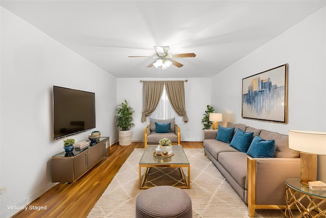 living room with light wood finished floors, baseboards, and a ceiling fan