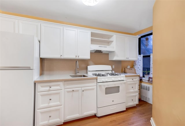 kitchen featuring under cabinet range hood, open shelves, a sink, radiator heating unit, and white appliances