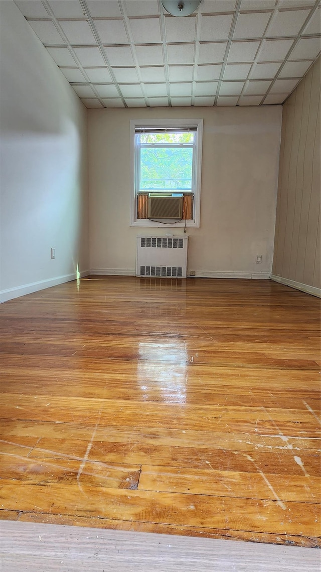 149-03 Reeves Ave, Flushing, NY 11367 - unfurnished room featuring radiator, cooling unit, light wood-style flooring, and wood walls