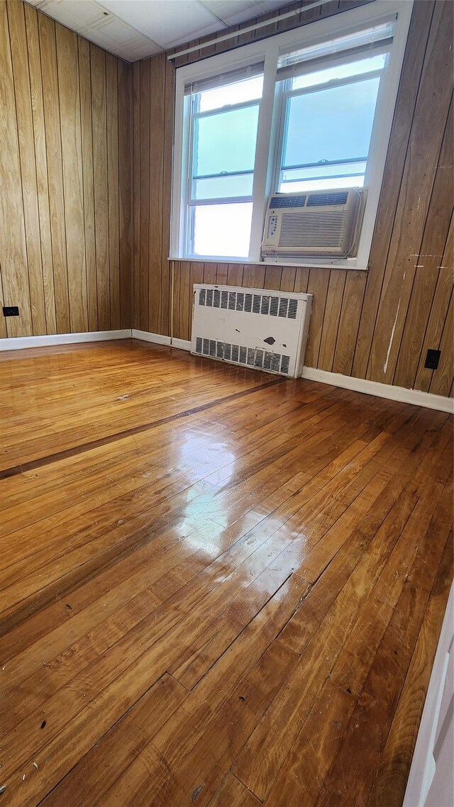 149-03 Reeves Ave, Flushing, NY 11367 - spare room with radiator, hardwood / wood-style flooring, wooden walls, and cooling unit