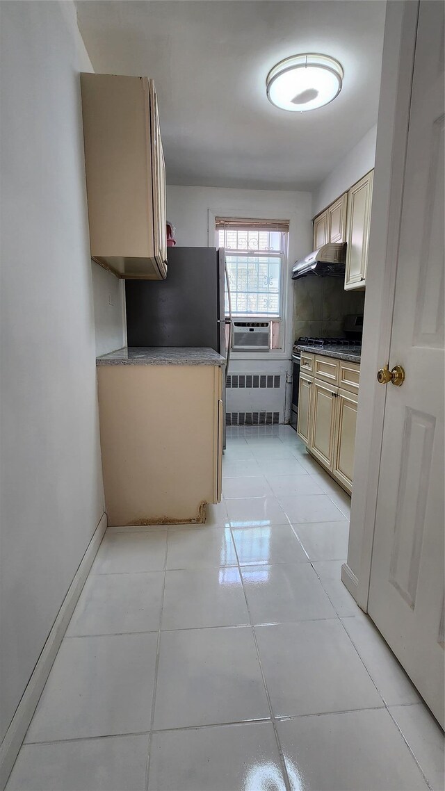 149-03 Reeves Ave, Flushing, NY 11367 - kitchen with cream cabinets, extractor fan, stainless steel appliances, tasteful backsplash, and light tile patterned floors