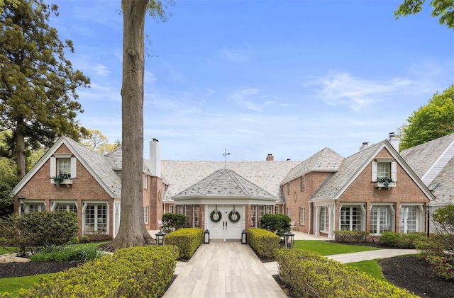 view of front of house with a high end roof and brick siding