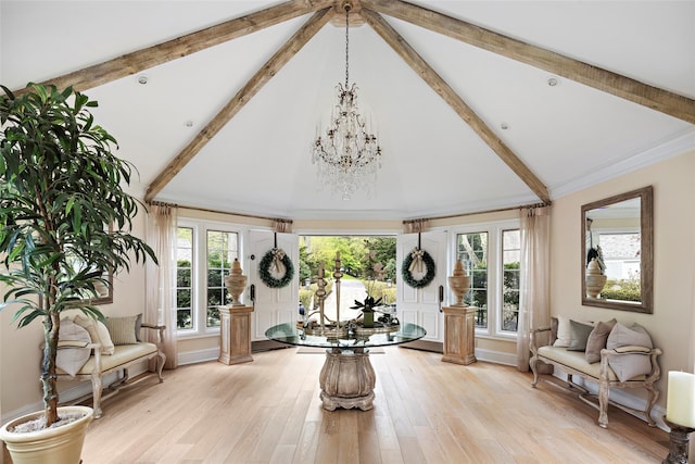 workout area with ornamental molding, light wood-style flooring, a notable chandelier, and high vaulted ceiling