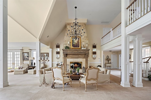 carpeted living room featuring a fireplace, visible vents, a towering ceiling, and a chandelier