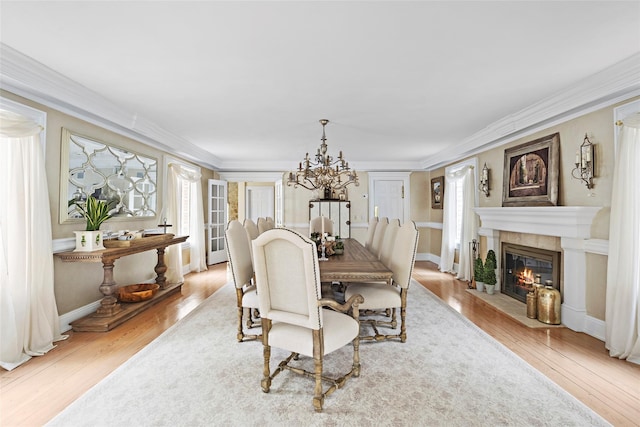 dining area with an inviting chandelier, crown molding, and wood finished floors