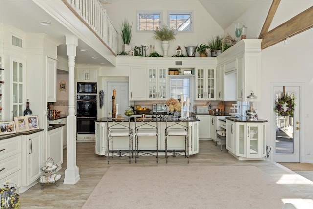 kitchen featuring decorative columns, dark countertops, and black appliances