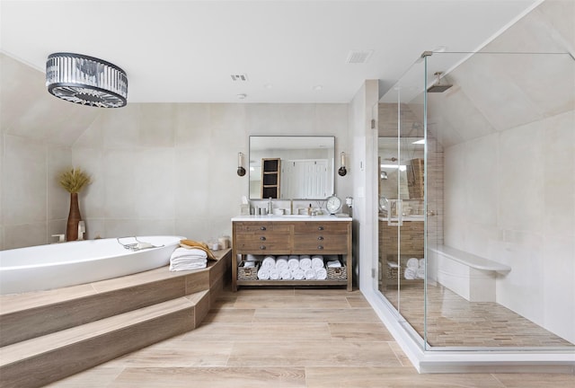 full bath with vanity, a shower stall, a garden tub, and visible vents