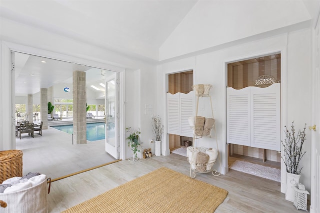 living area featuring light wood-style flooring and high vaulted ceiling