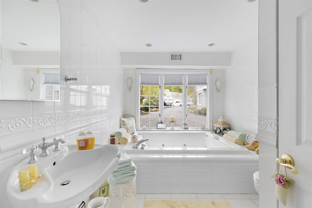 full bath with visible vents, a sink, a jetted tub, tile walls, and tile patterned flooring