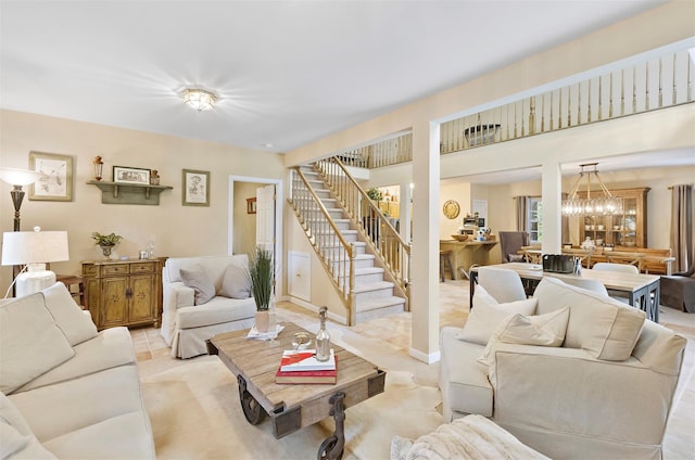 living area with a notable chandelier and stairs