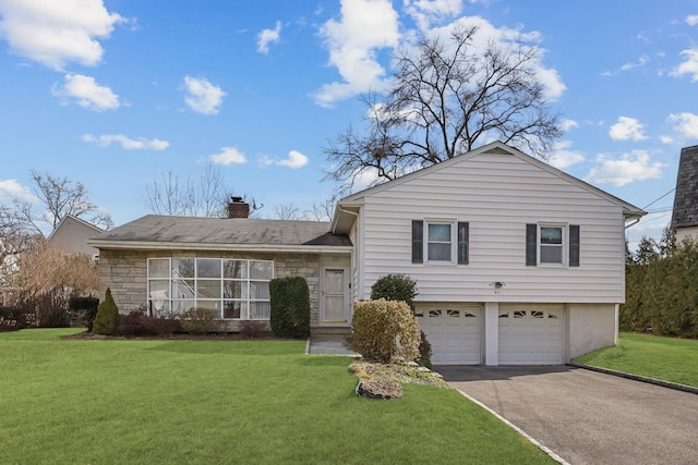 split level home with a front lawn, aphalt driveway, stone siding, a garage, and a chimney