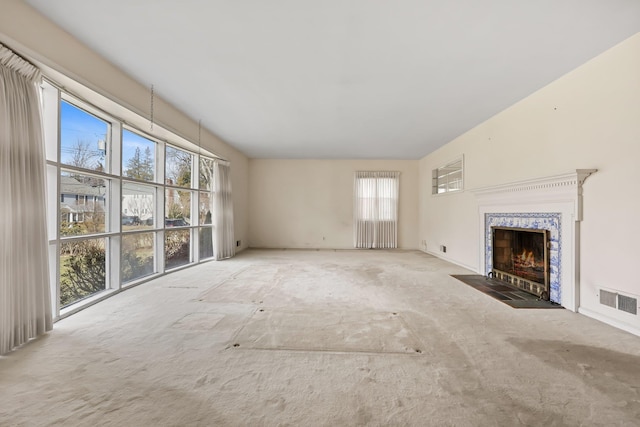 unfurnished living room with visible vents and a fireplace with flush hearth