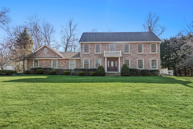 view of front facade with brick siding and a front lawn