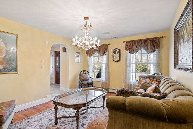 living room with wood finished floors, visible vents, baseboards, arched walkways, and a baseboard heating unit