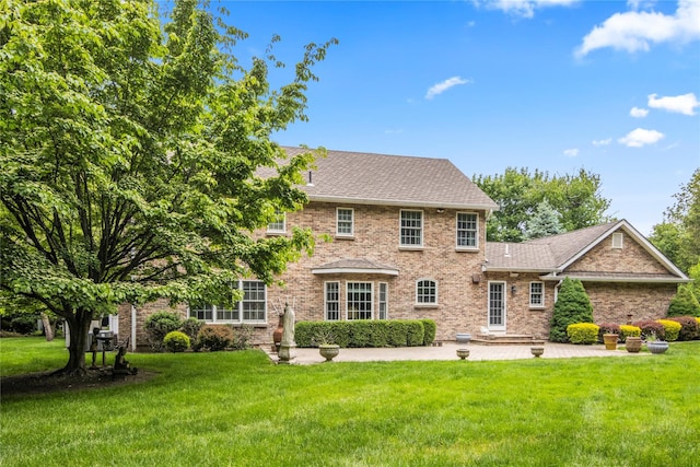10 Fairway Dr, Port Jefferson, NY 11777 - view of front of property with brick siding, a front lawn, a patio area, and roof with shingles