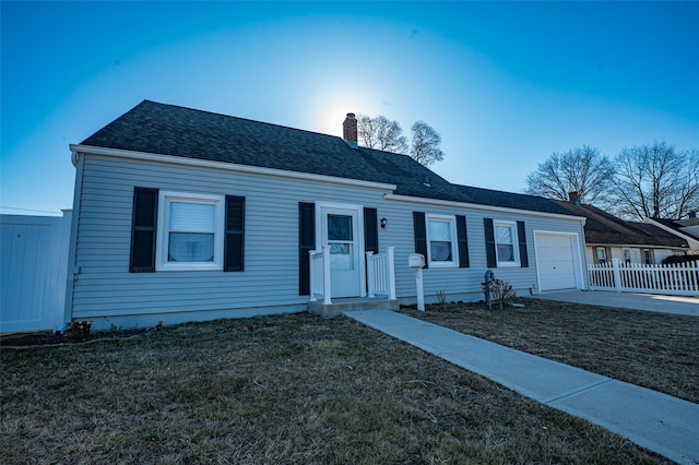 view of front of house with a front yard, fence, roof with shingles, a chimney, and a garage