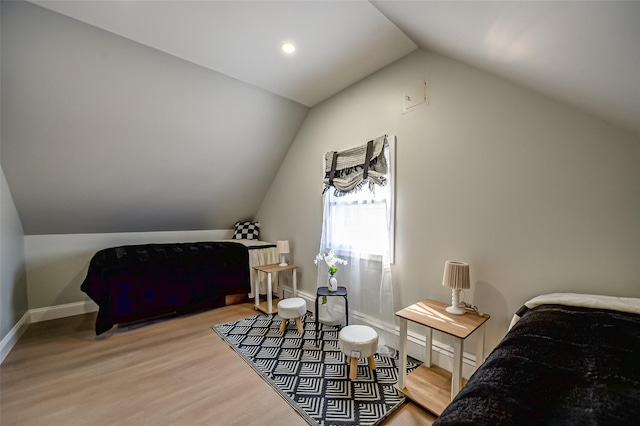 bedroom featuring lofted ceiling, wood finished floors, and baseboards