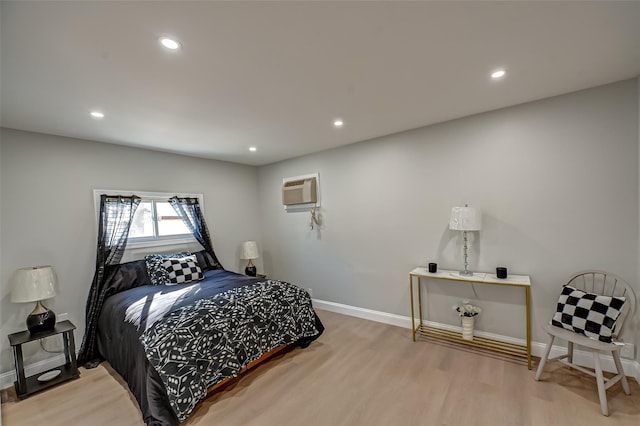 bedroom featuring recessed lighting, baseboards, wood finished floors, and a wall mounted AC