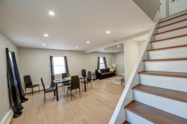 dining area featuring a baseboard heating unit, stairs, recessed lighting, and light wood-type flooring