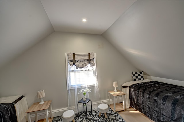 bedroom with wood finished floors and vaulted ceiling