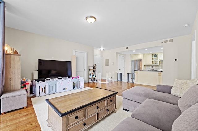 living room with visible vents and light wood-type flooring