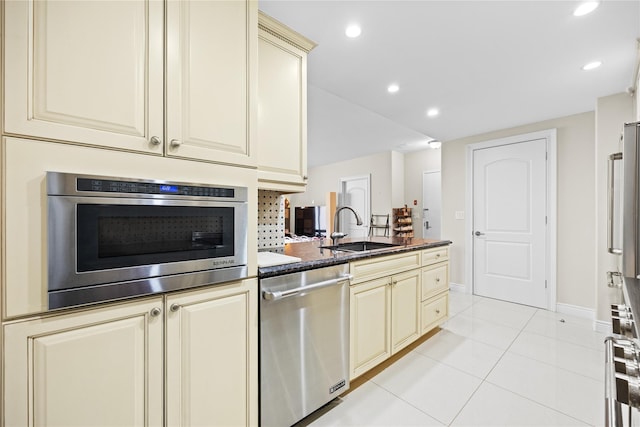 kitchen featuring a sink, cream cabinets, recessed lighting, stainless steel appliances, and light tile patterned flooring