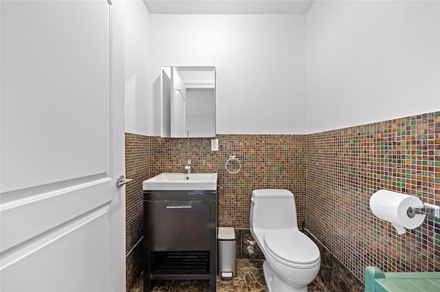 bathroom with vanity, tile walls, toilet, and wainscoting