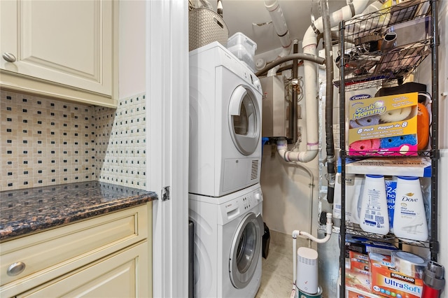 washroom featuring light tile patterned floors, cabinet space, and stacked washer and dryer