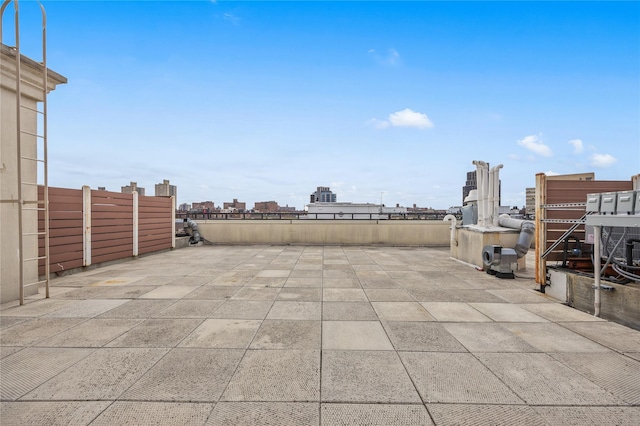 view of patio featuring a view of city and fence