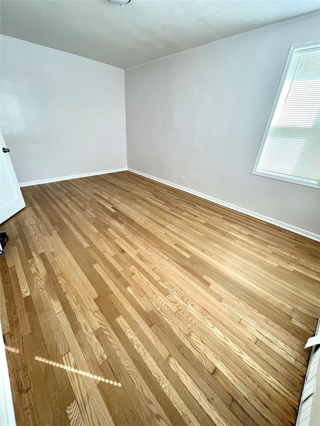 empty room featuring baseboards and wood finished floors