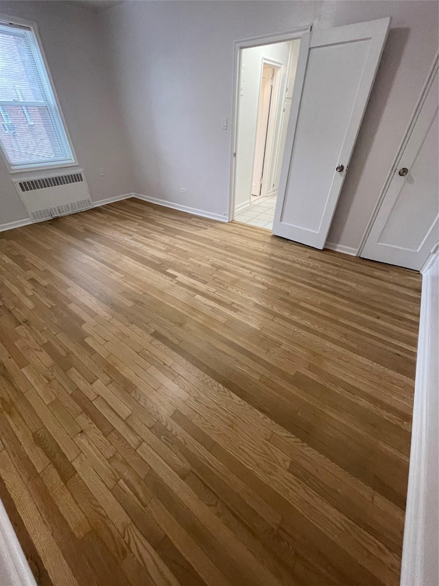 63-60 102nd St Unit B-14, Rego Park, NY 11374 - unfurnished bedroom with baseboards and light wood finished floors