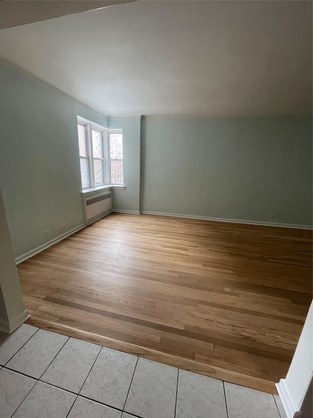 63-60 102nd St Unit B-14, Rego Park, NY 11374 - spare room featuring radiator heating unit, baseboards, and light wood-style floors
