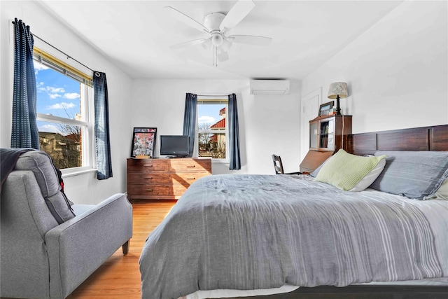 bedroom featuring an AC wall unit, wood finished floors, and ceiling fan