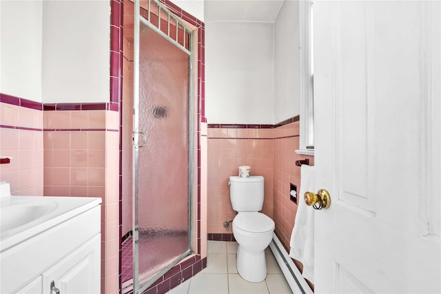 bathroom featuring tile patterned floors, a stall shower, a baseboard heating unit, tile walls, and vanity