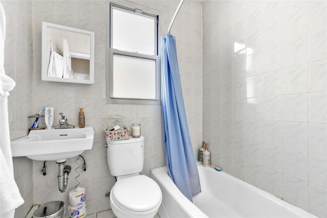 bathroom featuring a sink, toilet, tile walls, and shower / tub combo with curtain