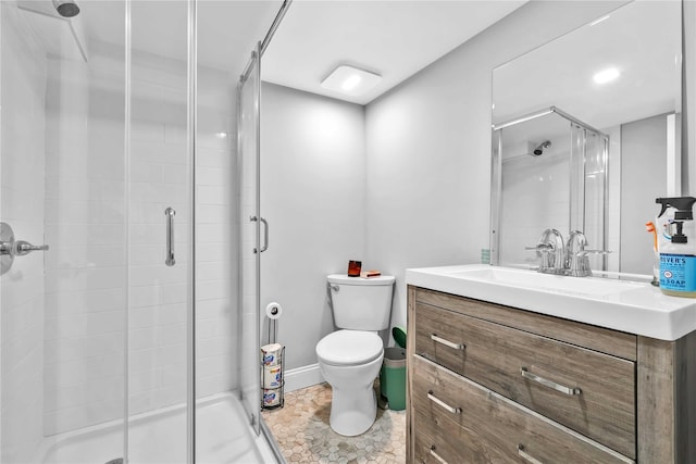 full bathroom with a stall shower, toilet, vanity, and baseboards