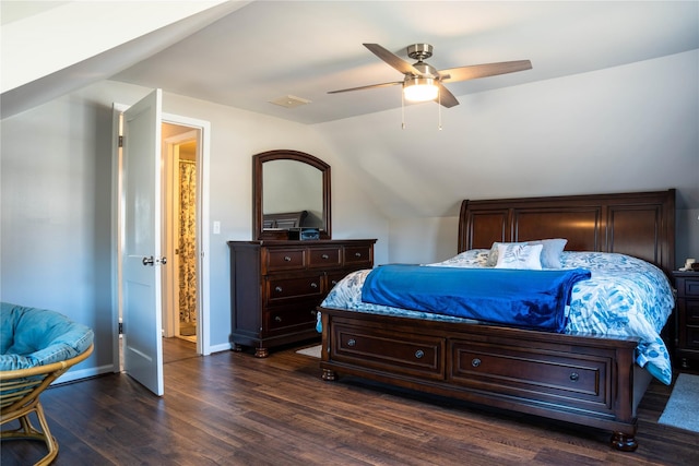 bedroom with dark wood-type flooring, vaulted ceiling, baseboards, and ceiling fan