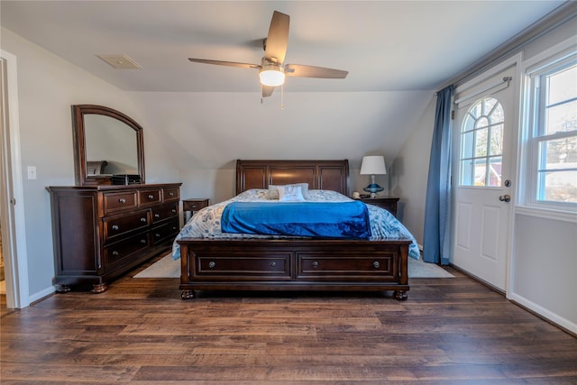 bedroom featuring lofted ceiling, dark wood-style floors, baseboards, and ceiling fan