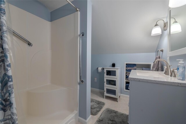 full bathroom with a shower with shower curtain, tile patterned floors, vanity, and vaulted ceiling