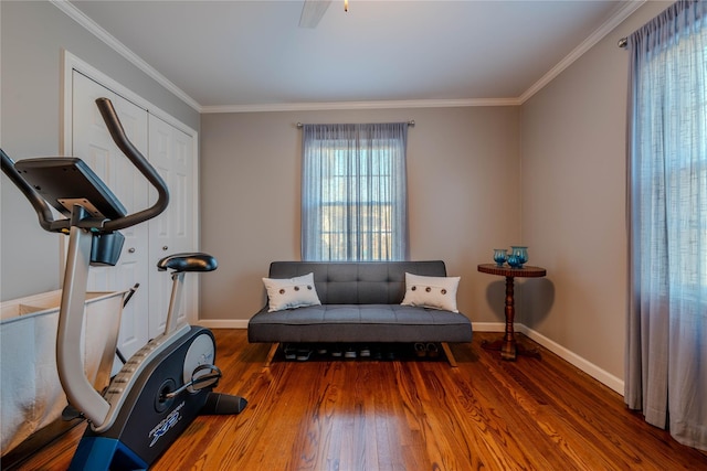 living area with baseboards, wood finished floors, and ornamental molding