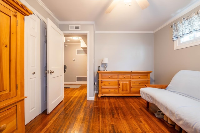 sitting room with visible vents, baseboards, dark wood-style floors, and ornamental molding