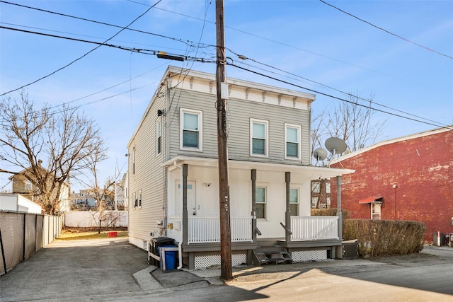 italianate home with a porch, fence, and central AC