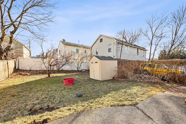 view of yard featuring a fenced backyard, an outdoor structure, and a shed