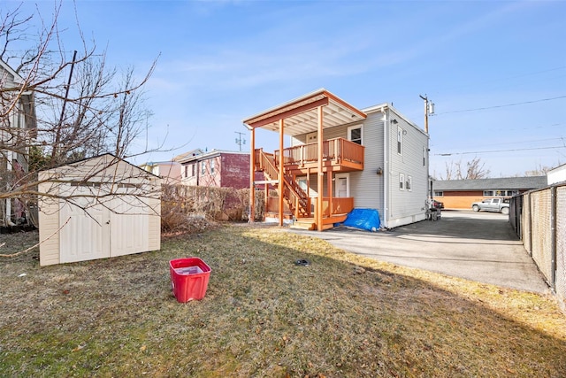 exterior space featuring an outbuilding, a lawn, a fenced backyard, a storage shed, and a wooden deck