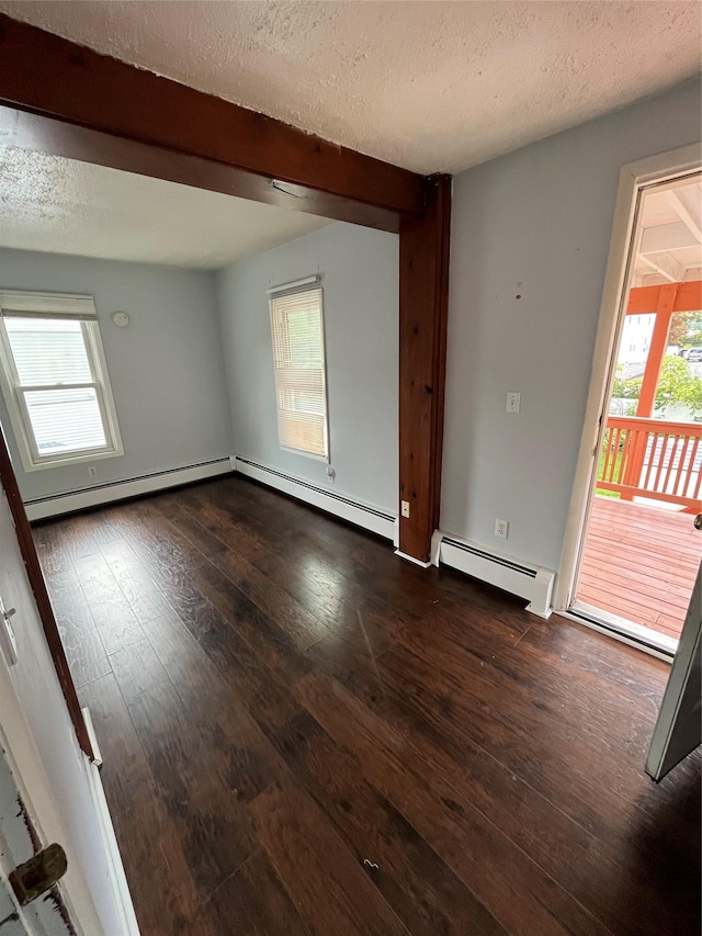 empty room featuring dark wood finished floors, a textured ceiling, beamed ceiling, and a baseboard radiator